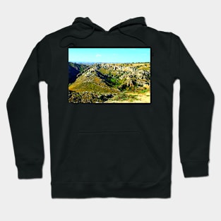 Rocky canyon partly covered with green grass and randomly placed shrubs near Matera Hoodie